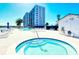 Outdoor pool and jacuzzi surrounded by lounge chairs, overlooking the bay at 9397 Midnight Pass Rd # 603, Sarasota, FL 34242