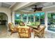 A sunroom overlooking the water features wicker furniture and bright green cushions at 9397 Midnight Pass Rd # 603, Sarasota, FL 34242