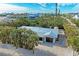 An aerial view of a single-story home with a metal roof and lush landscaping at 115 Los Cedros Dr, Anna Maria, FL 34216