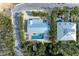 Aerial view of a home with private pool and lush landscaping, in a quiet coastal neighborhood at 115 Los Cedros Dr, Anna Maria, FL 34216