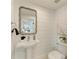 Small bathroom with pedestal sink, toilet and decorative mirror at 115 Los Cedros Dr, Anna Maria, FL 34216