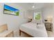 Bedroom with a queen bed and a window overlooking the garden at 115 Los Cedros Dr, Anna Maria, FL 34216