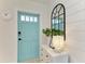 Inviting entryway with light teal door, shiplap wall, and stylish decor at 115 Los Cedros Dr, Anna Maria, FL 34216