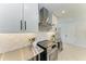 Modern kitchen with stainless steel appliances and white cabinets at 115 Los Cedros Dr, Anna Maria, FL 34216