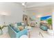 Spacious living area featuring a teal sectional sofa and large TV at 115 Los Cedros Dr, Anna Maria, FL 34216