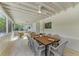 Bright screened porch with a dining table and seating area, perfect for outdoor living at 115 Los Cedros Dr, Anna Maria, FL 34216
