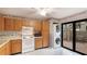 Galley kitchen with wood cabinets, appliances, and access to patio at 123 Pinehurst Dr, Bradenton, FL 34210