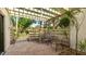 Private patio with pergola, comfortable seating, and tropical plants at 123 Pinehurst Dr, Bradenton, FL 34210