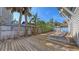 Spacious wooden backyard deck surrounded by lush greenery, perfect for lounging and outdoor enjoyment at 126/128 Avenida Veneccia, Sarasota, FL 34242