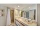 Well-lit bathroom featuring a double sink vanity, large mirror, and walk in shower at 126/128 Avenida Veneccia, Sarasota, FL 34242