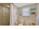 Neutral bathroom with a toilet, shower, and vanity; features decorative wall art and a bright window at 126/128 Avenida Veneccia, Sarasota, FL 34242