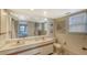 Bathroom featuring a double sink vanity, a large mirror, and natural light from the window at 126/128 Avenida Veneccia, Sarasota, FL 34242
