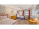 Cheerful bedroom featuring twin beds, colorful decor, a ceiling fan, and a bright window with curtains at 126/128 Avenida Veneccia, Sarasota, FL 34242