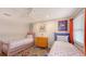 Cheerful bedroom with twin beds, colorful decor, a ceiling fan, and a bright window with curtains at 126/128 Avenida Veneccia, Sarasota, FL 34242