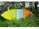 Close up of the Siesta Key Village sign with vibrant colors amidst lush greenery at 126/128 Avenida Veneccia, Sarasota, FL 34242