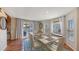 Bright dining room with white chairs, terracotta tile floor, sliding door to deck and water views at 126/128 Avenida Veneccia, Sarasota, FL 34242