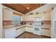 Well-lit kitchen with white appliances, ample cabinet space, and a cozy breakfast nook at 126/128 Avenida Veneccia, Sarasota, FL 34242