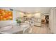 Bright kitchen featuring white cabinetry, tile flooring, and a dining area with seating for four at 126/128 Avenida Veneccia, Sarasota, FL 34242