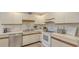Bright kitchen featuring white cabinetry, tile flooring, and modern appliances at 126/128 Avenida Veneccia, Sarasota, FL 34242
