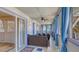 Enclosed patio features comfortable seating, blue curtains, ceiling fans, and sliding doors at 126/128 Avenida Veneccia, Sarasota, FL 34242
