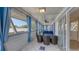 Enclosed patio with comfortable seating, blue curtains, a ceiling fan, and sliding glass doors at 126/128 Avenida Veneccia, Sarasota, FL 34242