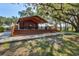 Community building with picnic tables and restrooms, shaded by large oak trees at 13207 49Th E Ln, Parrish, FL 34219