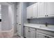 Bright laundry room with white cabinets and quartz countertops at 14721 Bowfin Ter, Lakewood Ranch, FL 34202