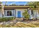 Mid-century modern home with blue door, stone path, and manicured landscaping at 1509 Flower Dr, Sarasota, FL 34239