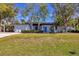 Mid-century modern home with carport, mature landscaping, and spacious lawn at 1509 Flower Dr, Sarasota, FL 34239
