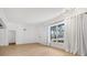 Spacious living room with large window, hardwood floors and access to hallway at 1509 Flower Dr, Sarasota, FL 34239