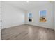 Bright bedroom featuring sleek, modern wood-look tile flooring and two large windows at 15610 San Lazzaro Ave, Bradenton, FL 34211