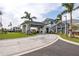 Grand community entrance featuring a porte cochere, lush landscaping, and an American flag at 15610 San Lazzaro Ave, Bradenton, FL 34211