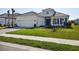 Stunning exterior of a well-manicured home with a two-car garage, verdant grass and walkway at 15610 San Lazzaro Ave, Bradenton, FL 34211