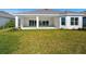 The rear exterior features a covered patio with sliding doors, overlooking the backyard and landscaping at 15610 San Lazzaro Ave, Bradenton, FL 34211