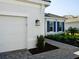 Charming home exterior with a white garage door, blue shutters, and a well-maintained walkway at 15610 San Lazzaro Ave, Bradenton, FL 34211
