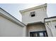 An upward angle of the entryway, blue front door, and light-gray exterior at 15610 San Lazzaro Ave, Bradenton, FL 34211