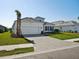 Beautiful exterior view of a one-story home with lush green grass, a brick driveway, and a 2-car garage at 15610 San Lazzaro Ave, Bradenton, FL 34211