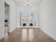 Bright foyer with chandelier, white walls, and wood-look tile flooring welcomes you into this lovely home at 15610 San Lazzaro Ave, Bradenton, FL 34211
