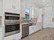 Modern kitchen with white cabinetry, stainless steel appliances, and tile flooring at 15610 San Lazzaro Ave, Bradenton, FL 34211
