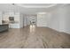 Open-concept floorplan with wood-look tile flooring connecting the living room and kitchen at 15610 San Lazzaro Ave, Bradenton, FL 34211