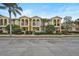 Three-story townhouses with arched entryways, balconies, and neatly landscaped yards at 1605 Napoli W Dr, Sarasota, FL 34232