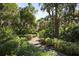 Brick pathway meanders through a lush, tropical garden at 1719 Starling Dr # 1719, Sarasota, FL 34231