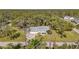 House with a large yard, driveway, and mature trees in an aerial view at 17402 Billiar Ave, Port Charlotte, FL 33948