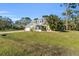 Yellow house with a screened porch and mature landscaping at 17402 Billiar Ave, Port Charlotte, FL 33948