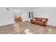 Bright living room with hardwood floors, a brown leather couch, and a dining area at 17402 Billiar Ave, Port Charlotte, FL 33948