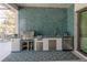 Outdoor kitchen with stainless steel appliances and teal tile backsplash at 1929 24Th Street W Cir, Palmetto, FL 34221