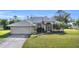 House exterior with a two-car garage and manicured lawn at 23159 Allen Ave, Punta Gorda, FL 33980