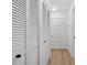 Hallway with light wood floors and built-in storage with white louvered doors at 2321 Beneva Ter # 2288, Sarasota, FL 34232