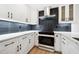 Modern kitchen with white cabinets, dark tile backsplash and stainless steel appliances at 2321 Beneva Ter # 2288, Sarasota, FL 34232