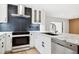 Modern kitchen with white cabinets, dark tile backsplash, and stainless steel appliances at 2321 Beneva Ter # 2288, Sarasota, FL 34232